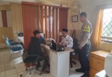 Bhabinkamtibmas Desa Mekarjaya Dampingi Perangkat Desa Berikan Pelayanan kepada Warga di Kantor Desa